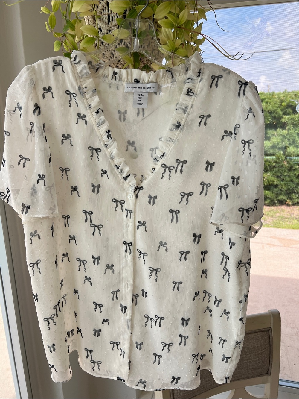 Cupcakes & Cashmere Cream Blouse with Ruffle Neckline / Black Bow Print. Size M